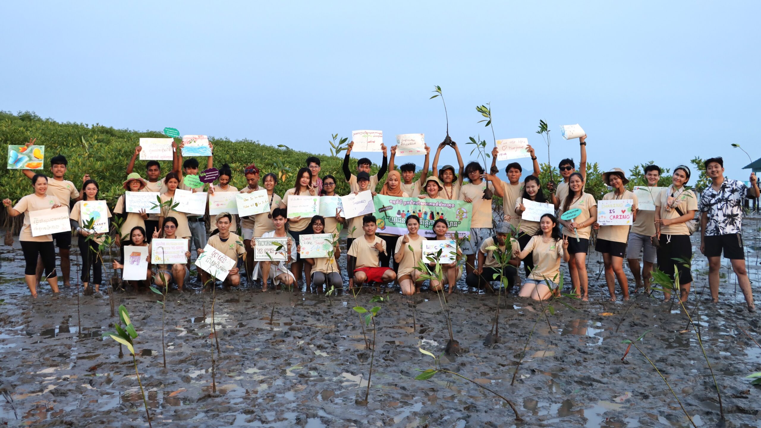Team building activity: youths take part in mangrove planting after showing their messages promoting environment protection.